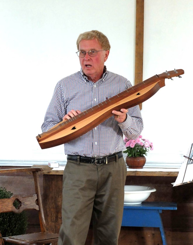 Photo of Rev. Froemming holding a dulcimer